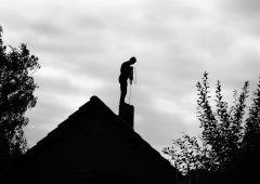 Contour of a chimney sweep, silhouetted against the light.Black and white photo.